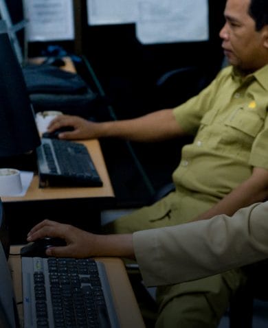A pair of security personnel working on computers.