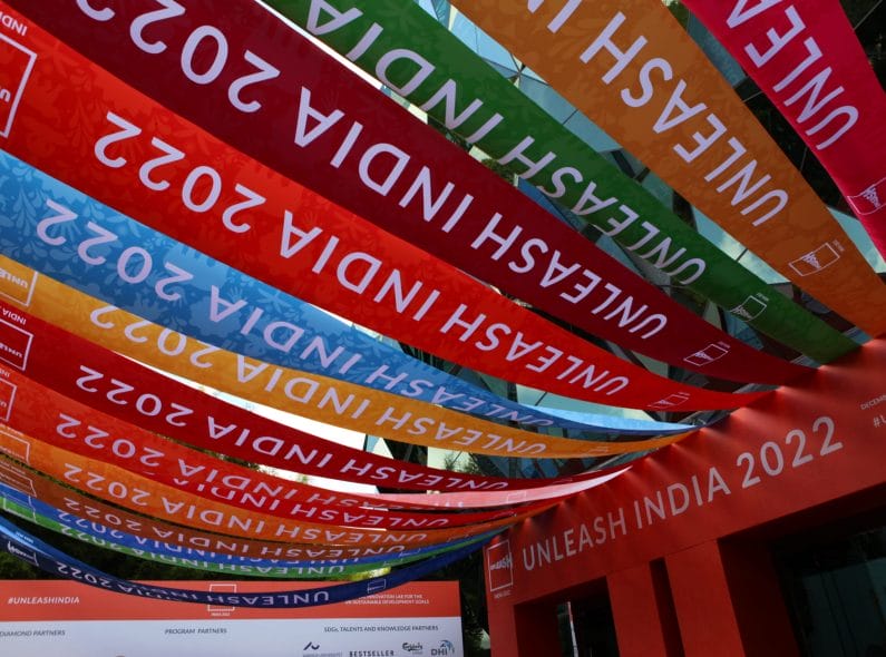 Multicolor banner flags with "UNLEASH India 2022" written across them